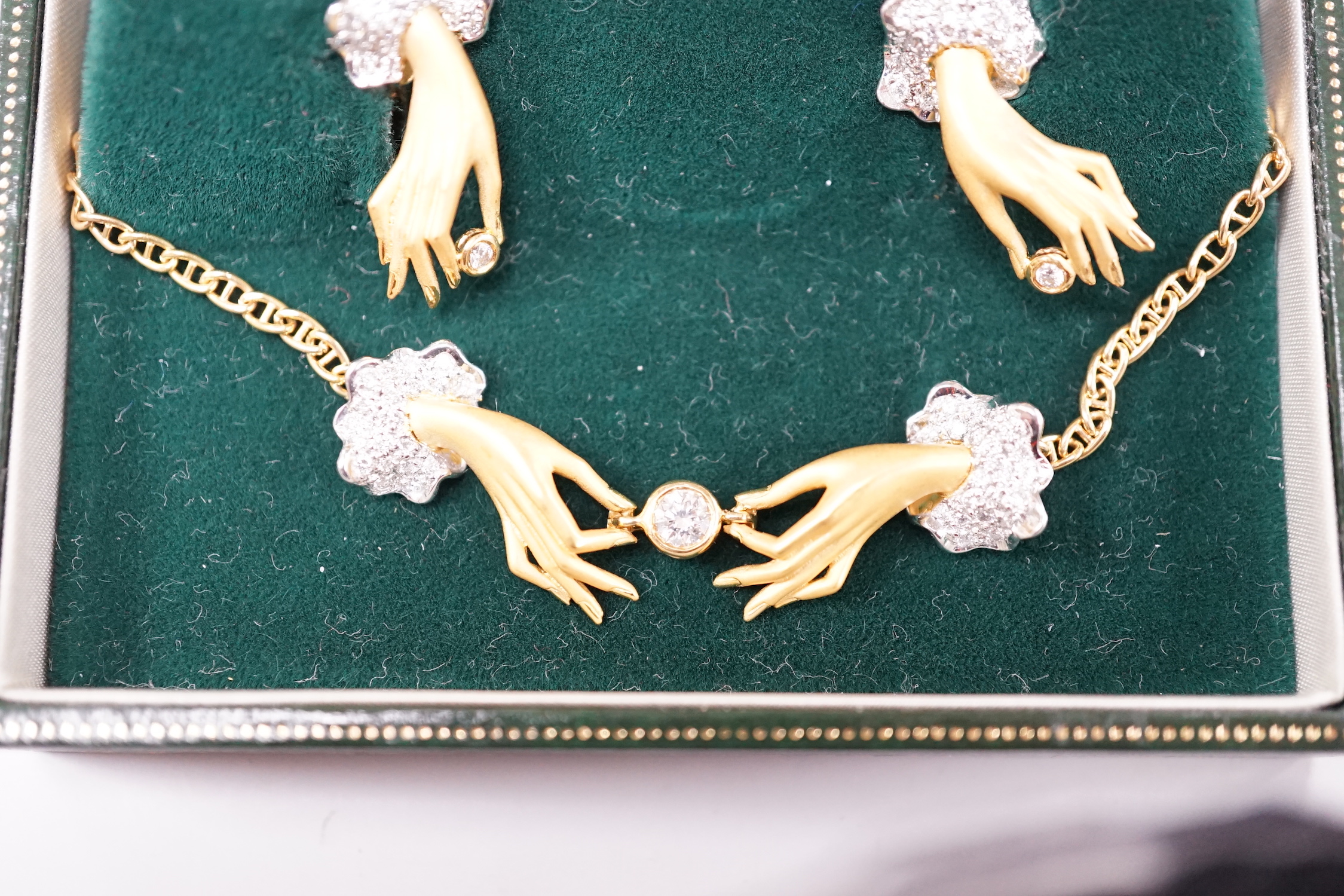 A modern Italian 750 yellow metal and diamond set Carrera Y Carrera suite of jewellery, comprising a necklace modelled as two diamond set hands holding a diamond and pair of matching ear studs, necklace 40cm, gross weigh